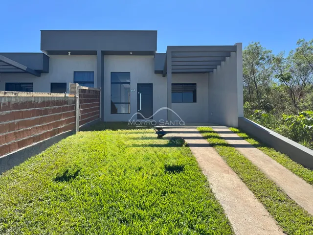 Exterior da casa moderna em Lajeado, com jardim e muro.