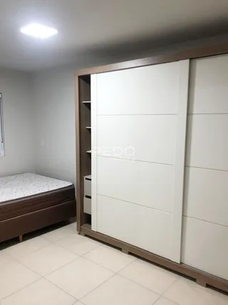 Quarto com armário embutido de madeira e portas brancas.