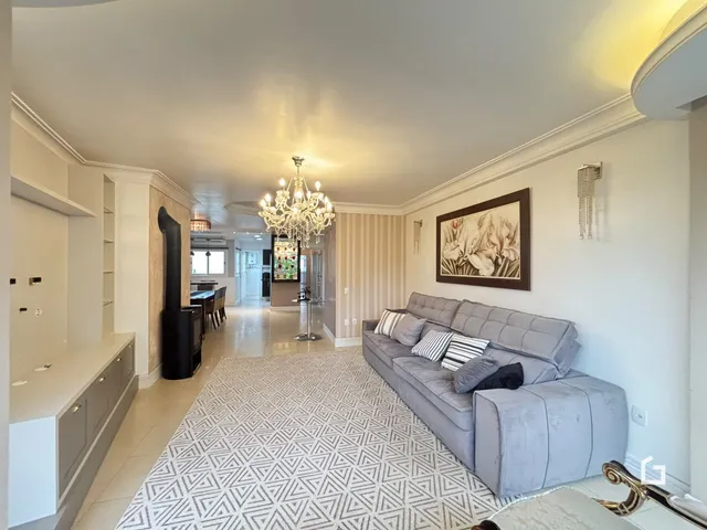 Sala de estar ampla com sofá cinza e iluminação elegante.