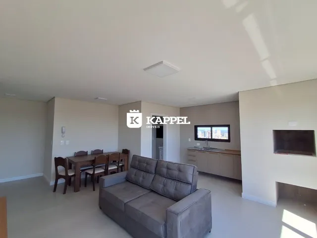 Sala de estar com sofá e mesa de jantar em um imóvel em Lajeado.