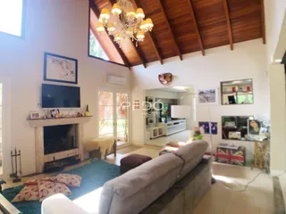 Sala de estar com lareira e teto de madeira em imóvel no Brasil.
