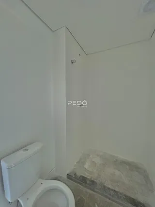Foto do canto de um banheiro com vaso sanitário branco.