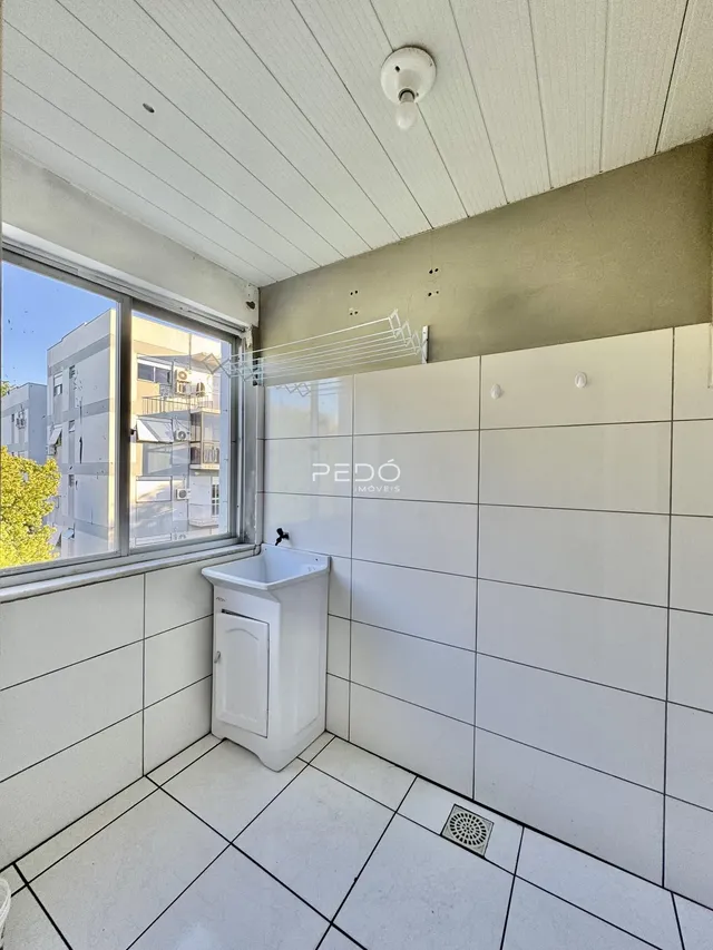 Foto de um banheiro com revestimento cerâmico branco.