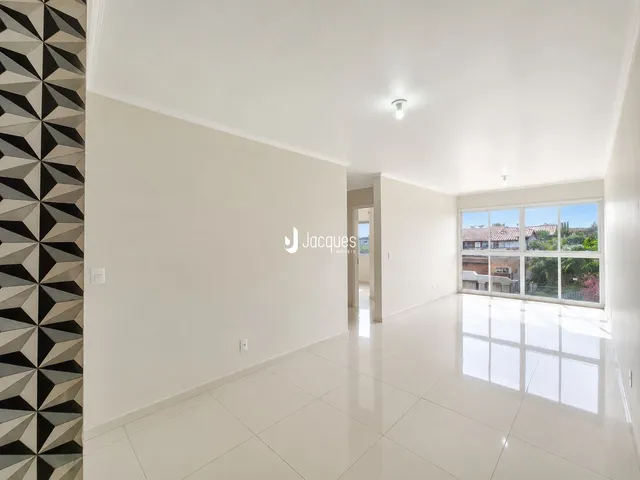 Ambiente interno de uma sala com piso de cerâmica e parede decorativa.
