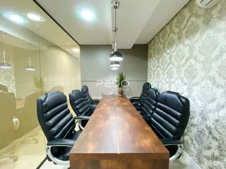 Uma mesa de jantar com cadeiras de couro preto em um ambiente interno.