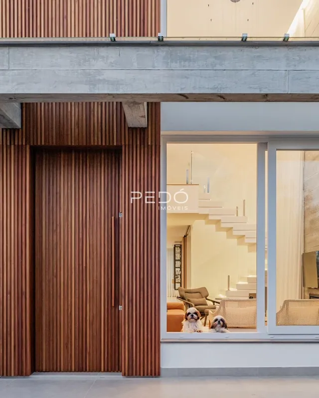 Fachada de uma residência moderna com porta de madeira e grande janela.