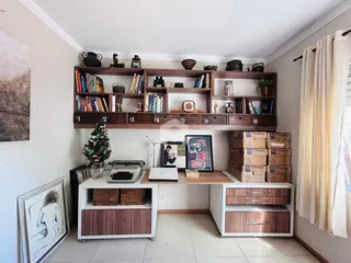 Ambiente interno com estantes de madeira e decoração na sala.