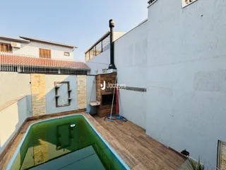 Vista externa de uma propriedade com piscina e parede de alvenaria.