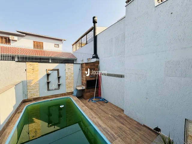 Vista externa de uma propriedade com piscina e parede de alvenaria.