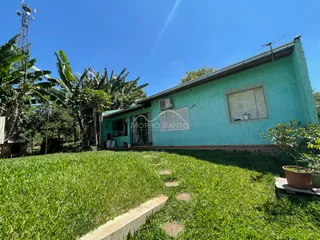 Fachada de uma casa azul-clara em Lajeado, com gramado verde em primeiro plano.