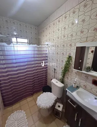 Foto de um banheiro com revestimento de parede e piso de cerâmica.