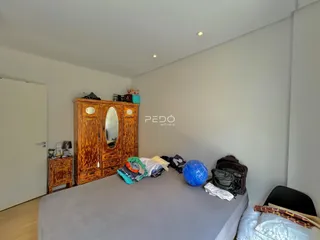 Quarto com armário de madeira e cama no interior de uma residência.