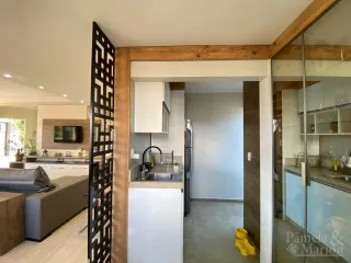 Foto de uma cozinha com armários brancos e bancada em um imóvel.