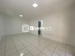 Foto de um cômodo interno amplo com piso de cerâmica branco.