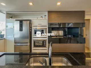 Cozinha moderna com bancada escura e eletrodomésticos em aço inoxidável.