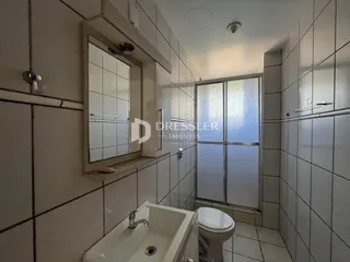 Foto de um banheiro com revestimento cerâmico branco.