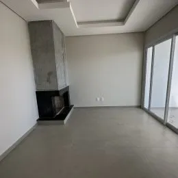 Sala de estar com parede de lareira e grande janela no ambiente.