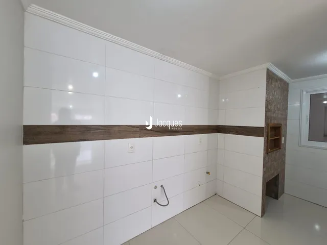 Parede interna com revestimento branco e detalhes em madeira marrom.