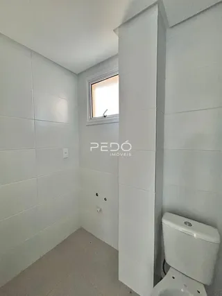 Hall de corredor interno com paredes brancas e uma janela.