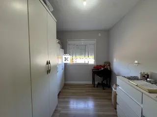 Um quarto com armários brancos e piso de madeira clara.