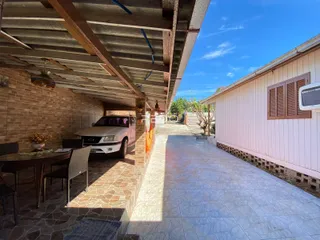 Vista externa de um pátio com piso de cerâmica e parede de tijolos.
