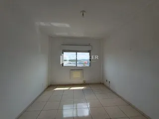 Vista interna de um ambiente com paredes brancas e piso de cerâmica.