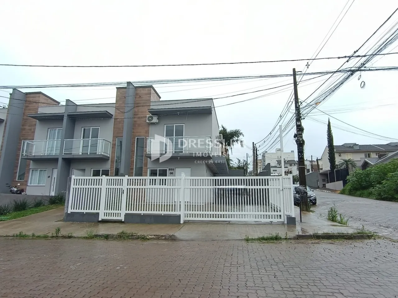 Fachada de um imóvel residencial em Lajeado, Brasil, com cerca branca.
