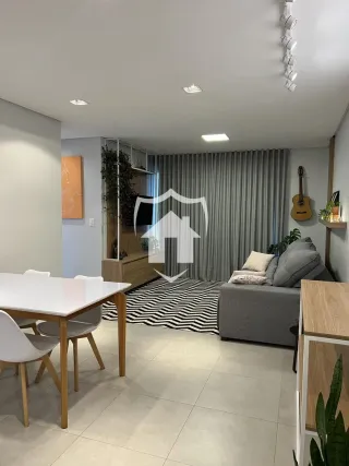 Ambiente interno de uma sala com mesa de jantar e sofá.