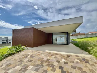 Fachada moderna de uma residência em Lajeado, Brasil, com revestimento marrom e grandes portas de vidro.
