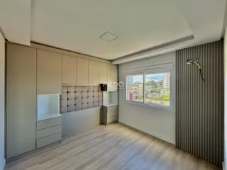 Uma sala de estar moderna com piso de madeira clara e armários embutidos.