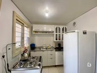 Cozinha com armários brancos e eletrodomésticos