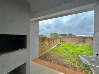 Vista de um quintal gramado com muro de tijolos.