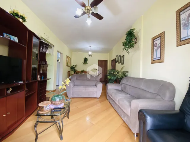 Sala de estar com sofás e móveis de madeira clara em um imóvel no Brasil.