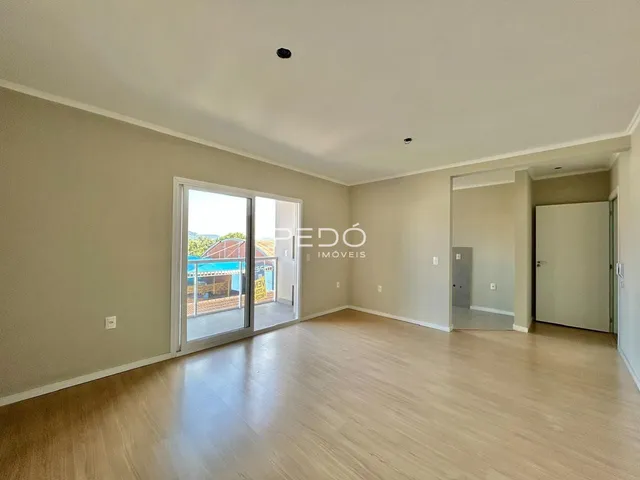 Sala de estar com piso de madeira clara e porta de vidro.