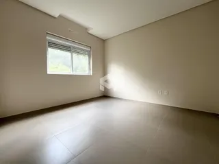 Ambiente interno de uma sala com piso de cerâmica e parede lisa.