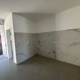Parede interna com revestimento de mármore claro em um imóvel.