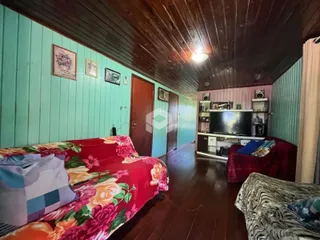 Quarto com paredes de madeira e teto inclinado em uma residência.