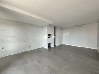 Ambiente interno amplo com paredes brancas e piso cinza claro.