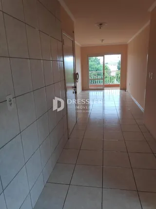 Corredor interno com piso de cerâmica claro e paredes brancas.