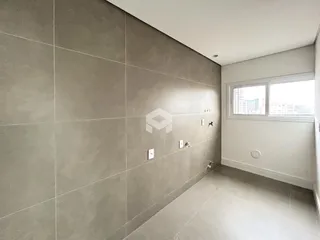 Parede interna com revestimento de cerâmica cinza em um imóvel.
