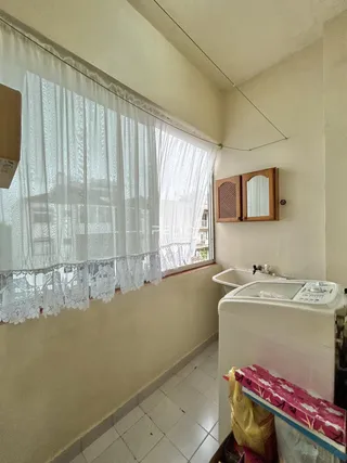 Vista de um corredor interno com janela coberta por cortinas de renda branca.