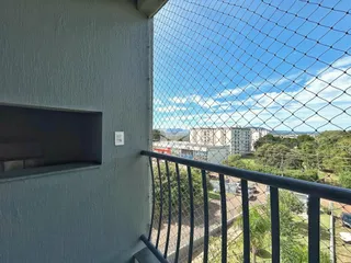 Vista da propriedade com grade de segurança e paisagem ao fundo.