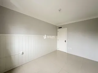 Ambiente interno com paredes brancas e piso de cerâmica em uma residência.