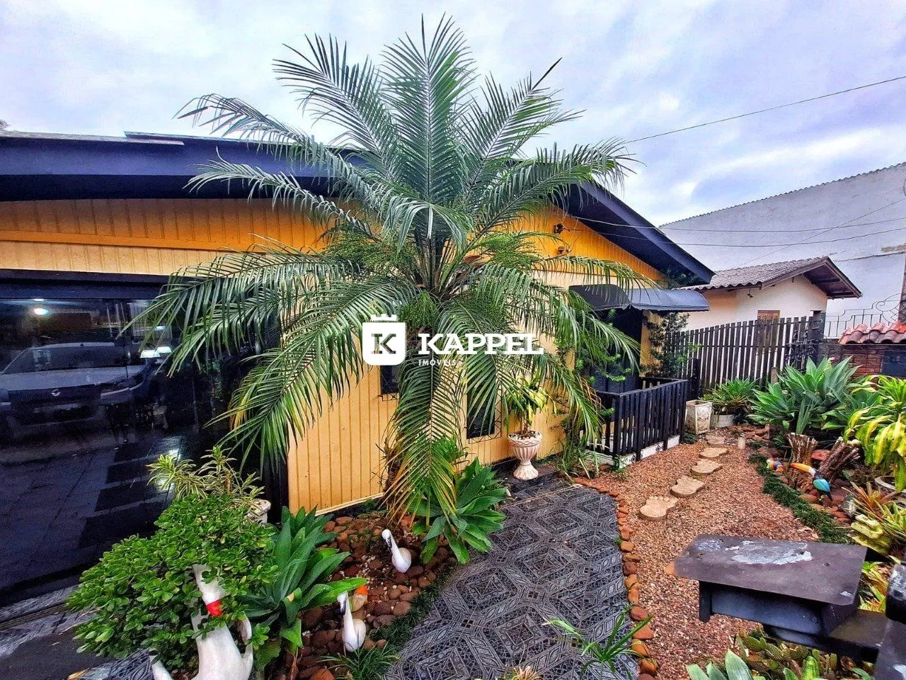 Fachada de uma residência em Lajeado, Brasil, com paisagismo tropical.