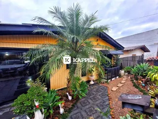 Fachada de uma residência em Lajeado, Brasil, com paisagismo tropical.