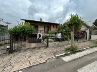 Fachada de uma casa em Lajeado, Brasil, com cerca e jardim na frente.