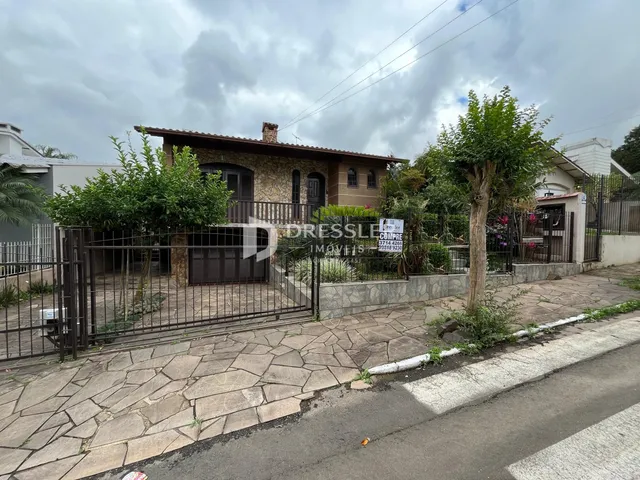 Fachada de uma casa em Lajeado, Brasil, com cerca e jardim na frente.