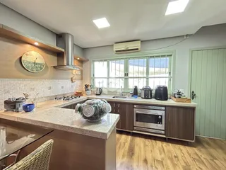 Cozinha com armários de madeira e piso de madeira clara.