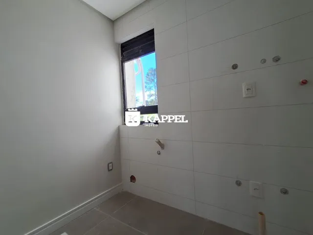 Vista interna de um corredor com parede branca e janela.