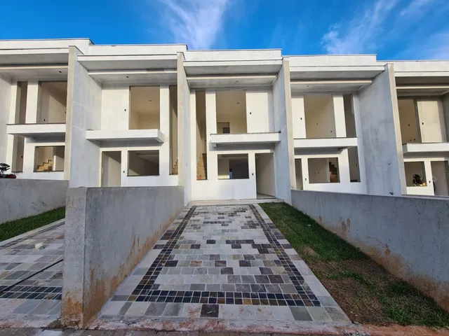 Fachada de um prédio residencial moderno em Lajeado, Brasil, com estrutura branca e pátio frontal.